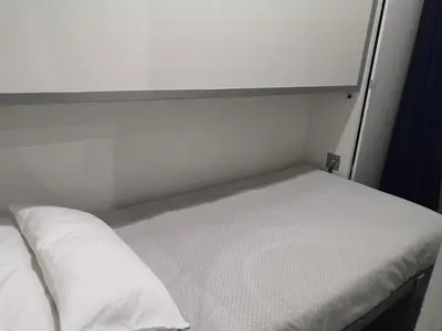 a bed in a small room with a white mattress at ApartEasy - Eixample Center in Barcelona