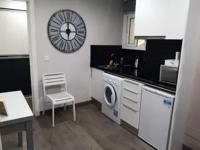a kitchen with a washing machine and a clock on the wall at ApartEasy - Eixample Center in Barcelona
