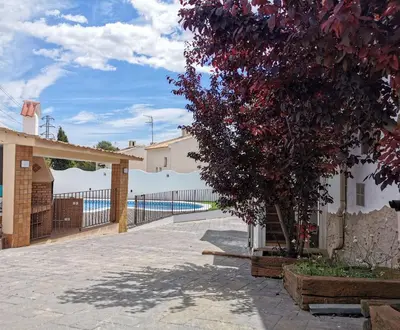 a tree in front of a building with a fence at Villa Playa y Montaña in Cunit