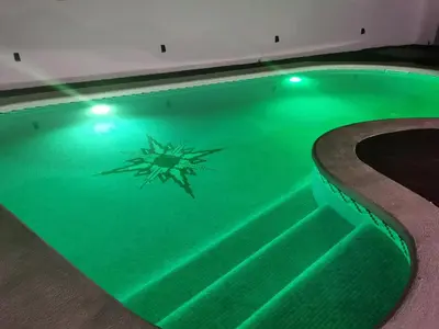 a swimming pool with a green light in the water at Villa Playa y Montaña in Cunit