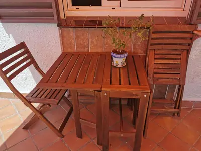 a wooden table and chair with a potted plant on it at Villa Playa y Montaña in Cunit