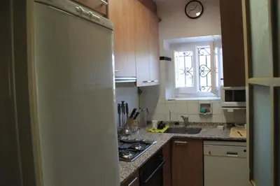 a kitchen with a refrigerator and a sink and a window at MAS GUILLO in San Quintín de Mediona