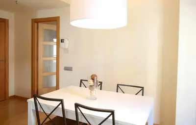 a white table with chairs and a vase on it at Mazi Apartments Downtown in Mataró