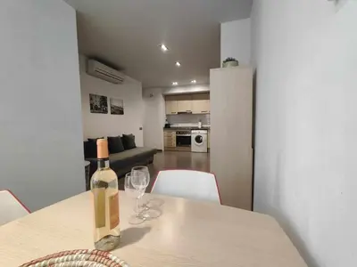 a bottle of wine sitting on a table with wine glasses at Mazi Apartments Nest in Mataró