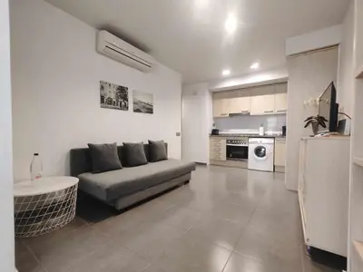 a living room with a couch and a kitchen at Mazi Apartments Nest in Mataró