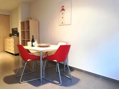 a table with four red chairs in a room at Mazi Apartments Nest in Mataró