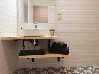 a bathroom with a sink and a mirror and towels at Mazi Apartments Penthouse in Badalona