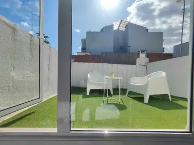 a window with two chairs and a table on a balcony at Mazi Apartments Penthouse in Badalona