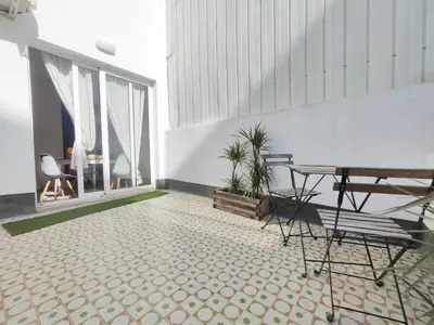 a room with a table and chairs on a tile floor at Mazi Apartments Penthouse in Badalona