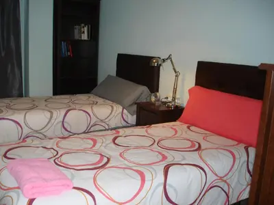 a bedroom with two beds and a pink blanket at LA NURSERY DE MAS GUILLO in San Quintín de Mediona
