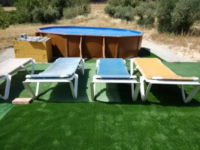 a ping pong table and two lounge chairs on the grass at LA NURSERY DE MAS GUILLO in San Quintín de Mediona