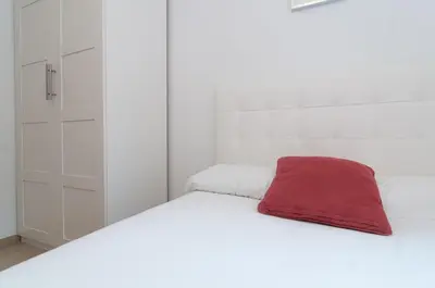 a white bed with a red pillow on it at Private terrace at Sagrada Familia in Barcelona