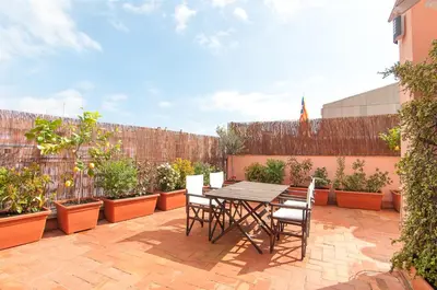 a patio with a table and chairs and potted plants at Private terrace at Sagrada Familia in Barcelona