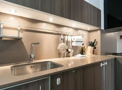 a kitchen with a stainless steel sink and wooden cabinets at Private terrace at Sagrada Familia in Barcelona