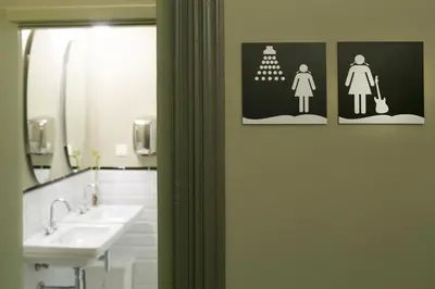a bathroom with two sinks and a sign on the wall at Sant Jordi Hostels Rock Palace in Barcelona