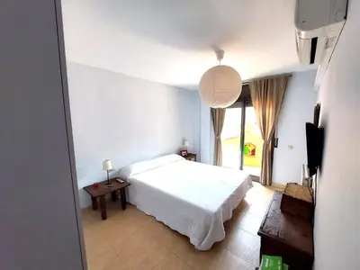 a bedroom with a white bed and a large window at BRAVAHOLIDAYS-201-Pineda in Pineda de Mar