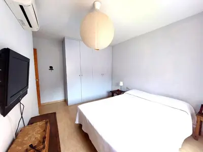 a bedroom with a bed and a flat screen tv at BRAVAHOLIDAYS-201-Pineda in Pineda de Mar
