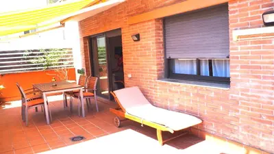 a patio with a table and chairs and a brick wall at BRAVAHOLIDAYS-201-Pineda in Pineda de Mar