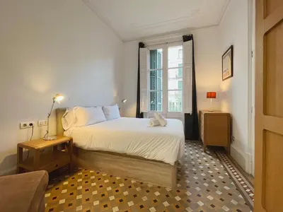 a bedroom with a large bed and a window at Stay Unique Apartments Bruc in Barcelona