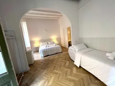 two beds in a white room with an archway at The MO GOTIC in Barcelona