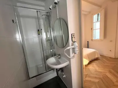 a bathroom with a shower with a sink and a mirror at The MO GOTIC in Barcelona