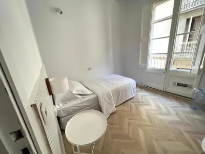 a small white room with a bed and a table at The MO GOTIC in Barcelona