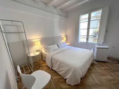 a white bedroom with a white bed and a window at The MO GOTIC in Barcelona