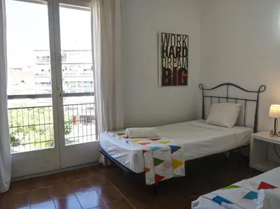 a bedroom with two beds and a large window at Clarimar Sky Blue by Hello Homes Sitges in Sitges