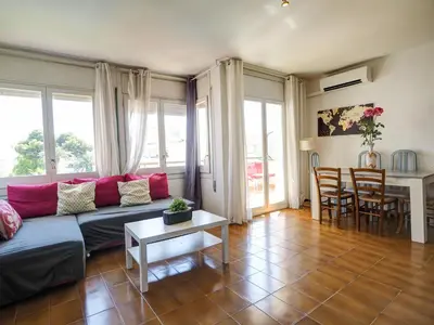 a living room with a couch and a table at Clarimar Sky Blue by Hello Homes Sitges in Sitges