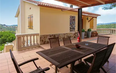 a patio with a table and chairs on a balcony at Nice Home In Sant Cebria De Vallalt in Sant Cebrià de Vallalta