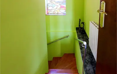 a stairway with a green wall and a stained glass window at Nice Home In Sant Cebria De Vallalt in Sant Cebrià de Vallalta