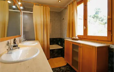 a bathroom with two sinks and a window at Nice Home In Sant Cebria De Vallalt in Sant Cebrià de Vallalta