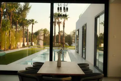 a dining room with a table and chairs and a pool at Contemporary villa near Sitges Hills in Avinyonet