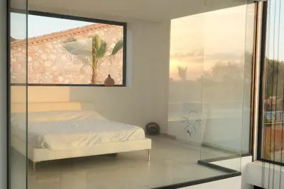a bedroom with a bed and a glass wall at Contemporary villa near Sitges Hills in Avinyonet