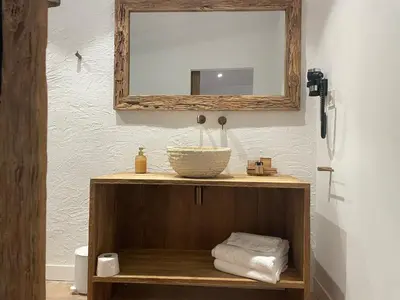 a bathroom with a sink and a mirror and towels at La Mer Hotel in Cabrera de Mar