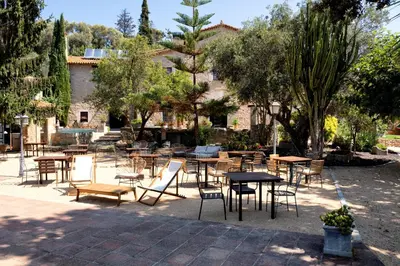 a group of tables and chairs in a courtyard at La Mer Hotel in Cabrera de Mar