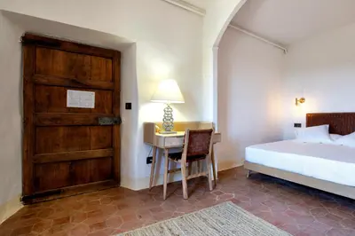 a bedroom with a bed and a desk with a lamp at La Mer Hotel in Cabrera de Mar