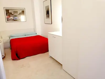 a white room with a bed with a red blanket at Enric Granados 15 in Barcelona