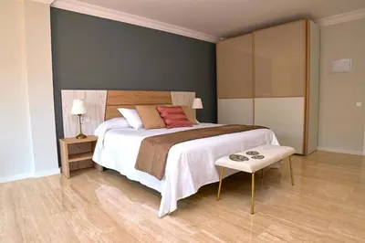a bedroom with a large bed and a table at Can Mir Badalona in Badalona