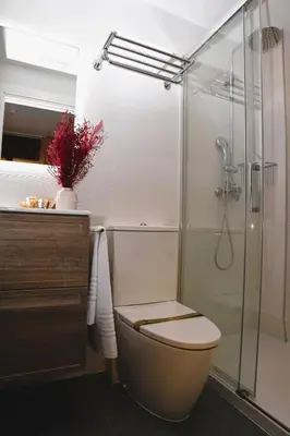 a bathroom with a toilet and a glass shower at Can Mir Badalona in Badalona
