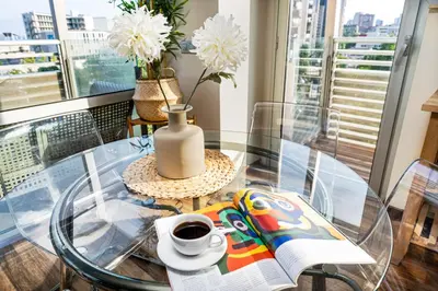 a glass table with a vase and a cup of coffee at Lodging Apartments Forum Llull in Sant Adria de Besos