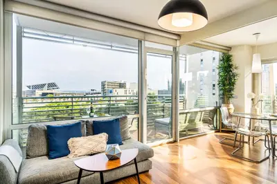 a living room with a couch and a large window at Lodging Apartments Forum Llull in Sant Adria de Besos