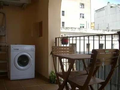 a washing machine and a table on a balcony at Apart céntrico con terraza en Gracia in Barcelona