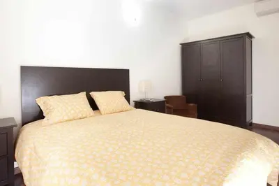 a bedroom with a large bed and a black cabinet at Apart céntrico con terraza en Gracia in Barcelona