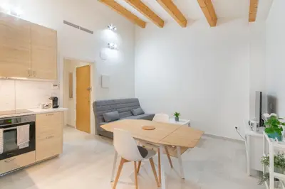 a kitchen and living room with a table and a couch at NICE CITY CENTER APARTMENT in Vilanova i la Geltrú