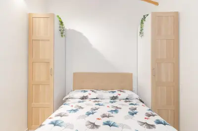 a bedroom with two doors and a bed at NICE CITY CENTER APARTMENT in Vilanova i la Geltrú