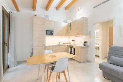 a kitchen and dining room with a wooden table and chairs at NICE CITY CENTER APARTMENT in Vilanova i la Geltrú