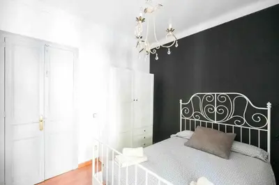 a bedroom with a white bed and a chandelier at Port VIII Apart céntrico en Paralelo cerca Rambla in Barcelona