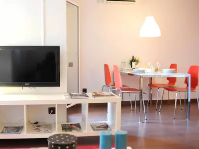 a living room with a tv and a table with chairs at Your Home in Barcelona Apartments in Barcelona