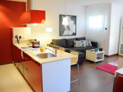 a kitchen with a sink and a living room with a couch at Your Home in Barcelona Apartments in Barcelona